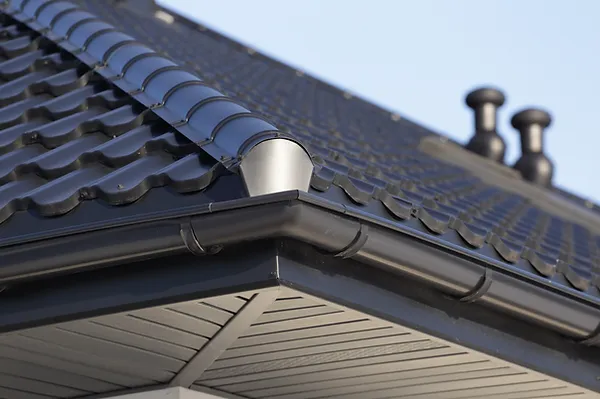 Gutter guards installed on home with black metal roof