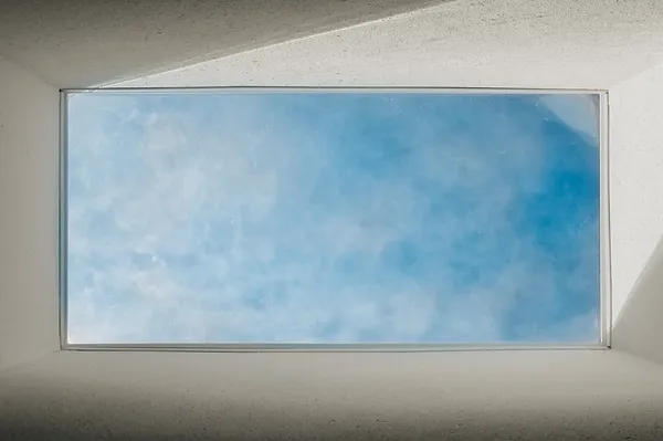 skylight installed in home with blue sky and clouds